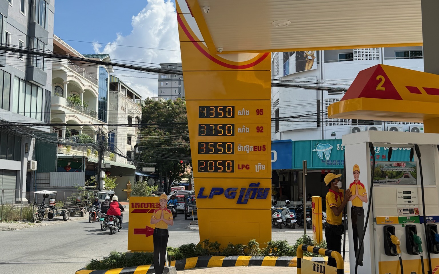 Peace Petroleum city station in Phnom Penh in operation — AVS LED price pylon lit with 95, 92, EU5 and LPG prices under the new canopy