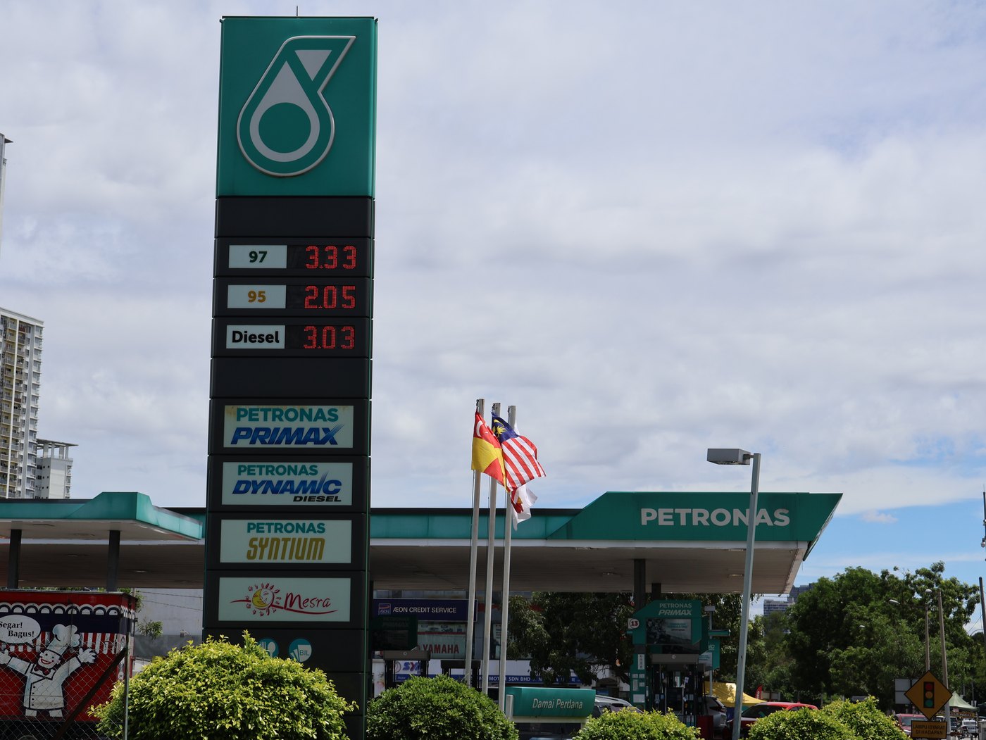 AVS LED price display running on a Petronas station monolith — 97, 95 and Diesel prices in red LED digits