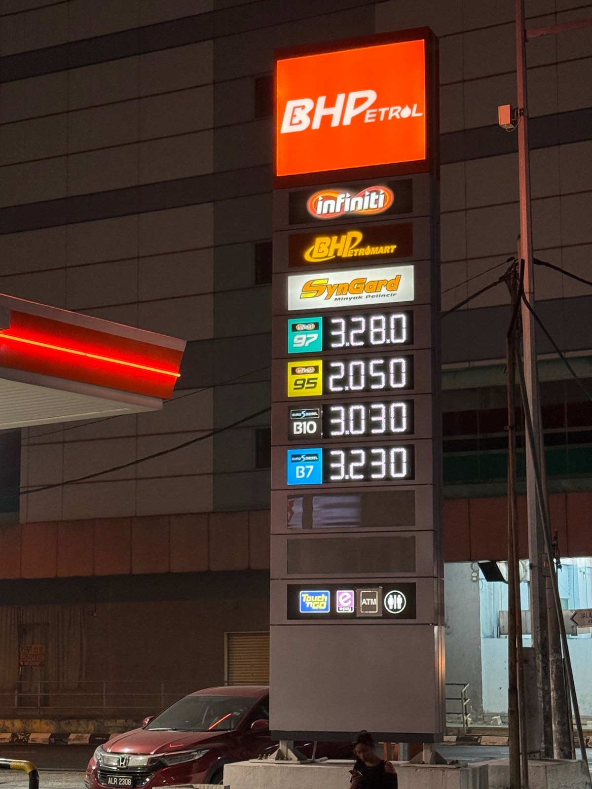BHP price pylon at night with every fuel grade lit in red LED digits