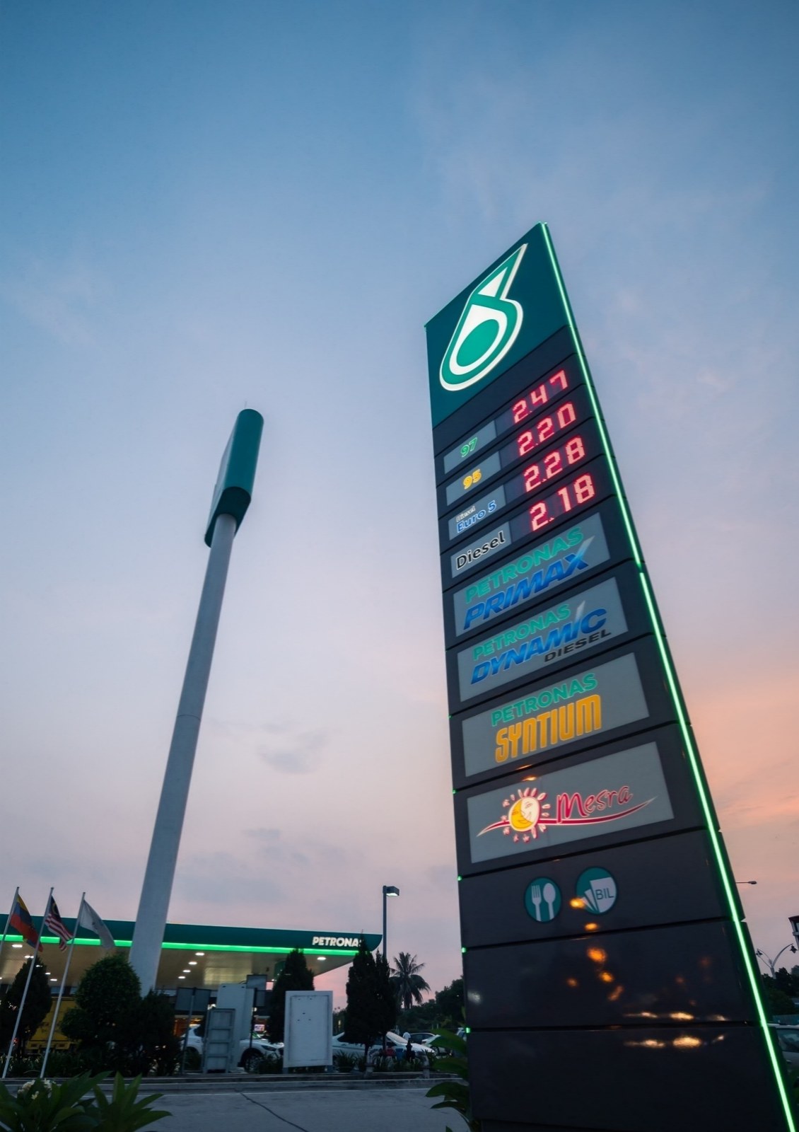 Full Petronas pylon at dusk showing the PCU fuel-price display in place
