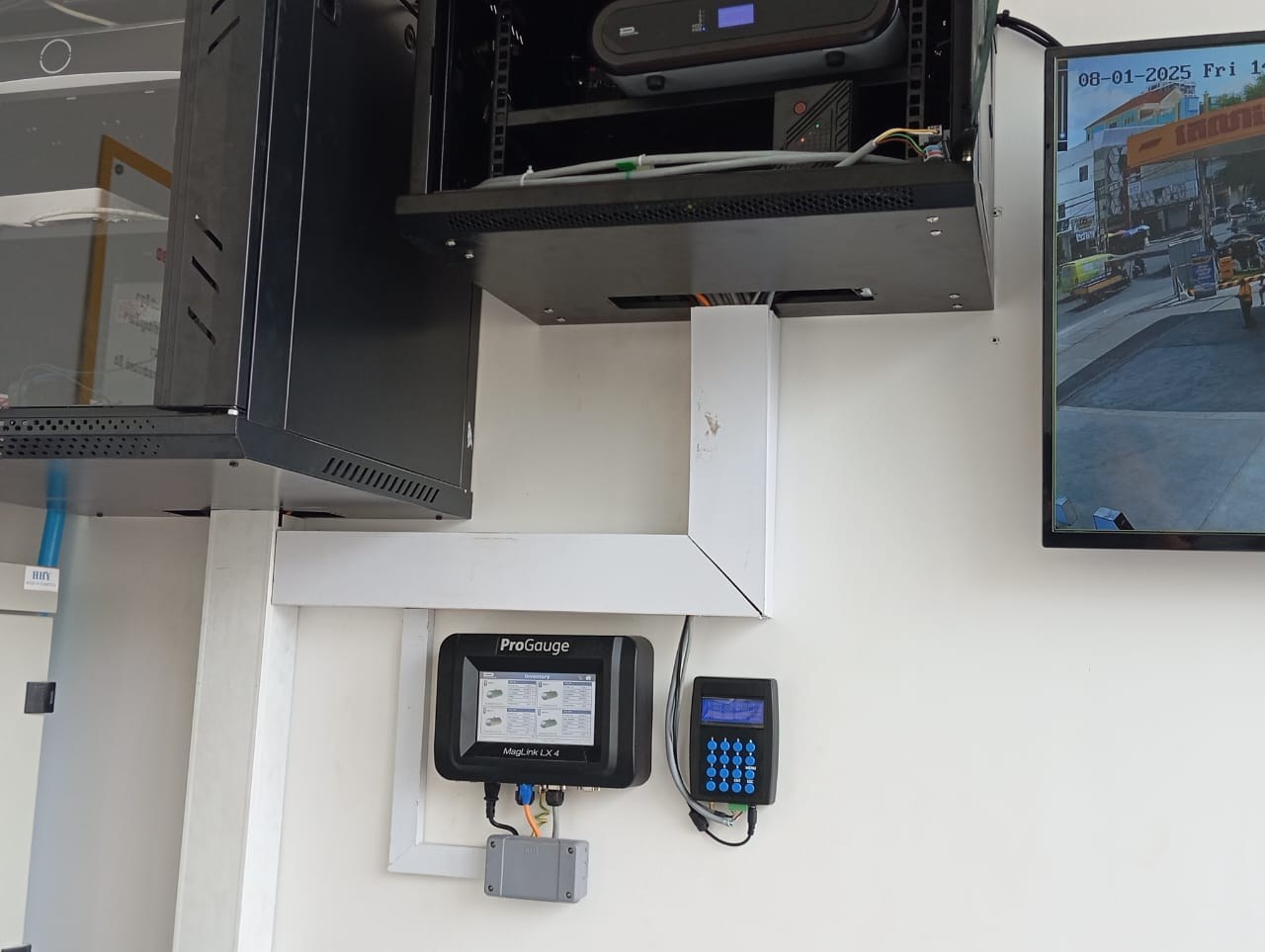 POS / forecourt setup at the counter — ProGauge console and AVS price terminal linked to the station system