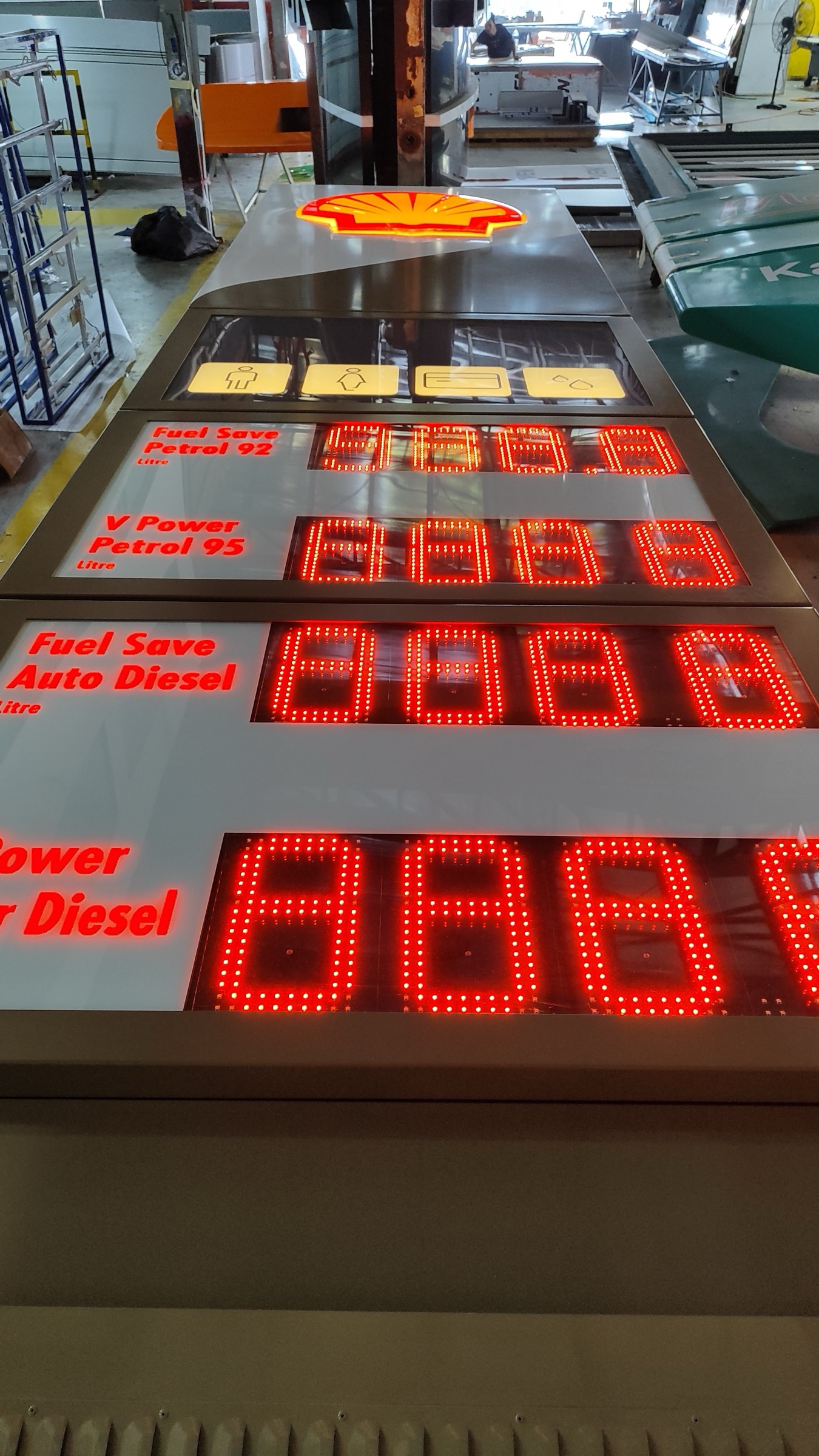 Shell price sign assemblies lit for testing at the AVS factory — Fuel Save and V Power panels with red LED digits