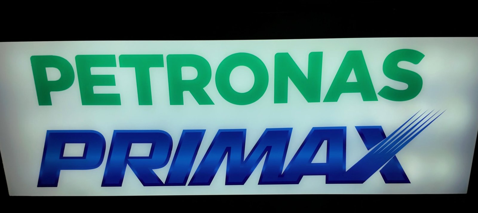 Forecourt brand panel lit from behind — the printed face reads evenly edge to edge with no visible hotspots or dark bands