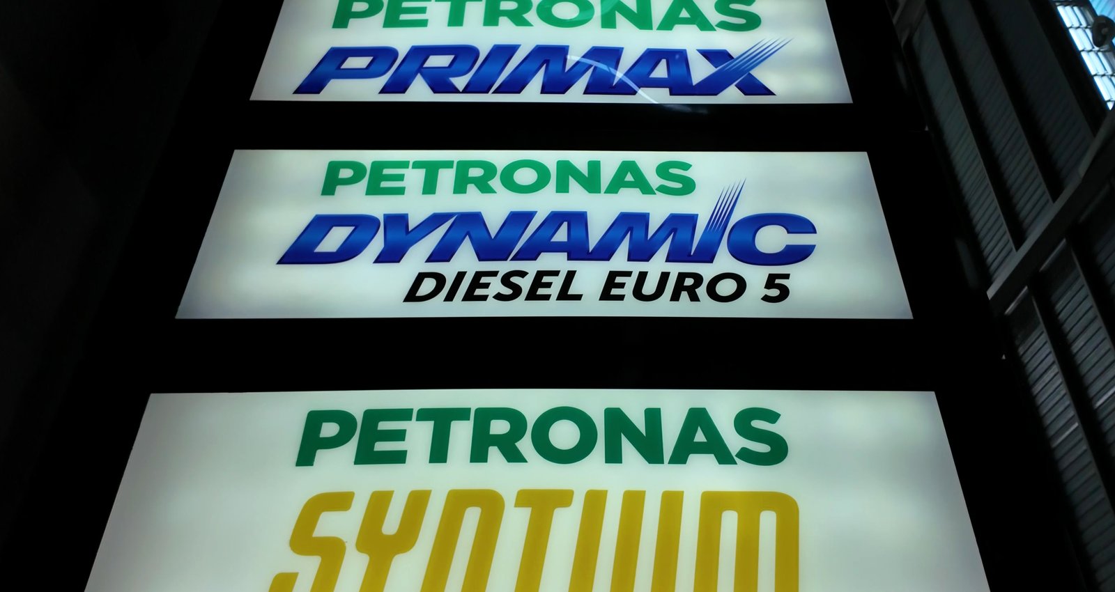 Stacked forecourt grade panels lit from behind — Primax, Dynamic Diesel Euro 5 and Syntium reading cleanly at night