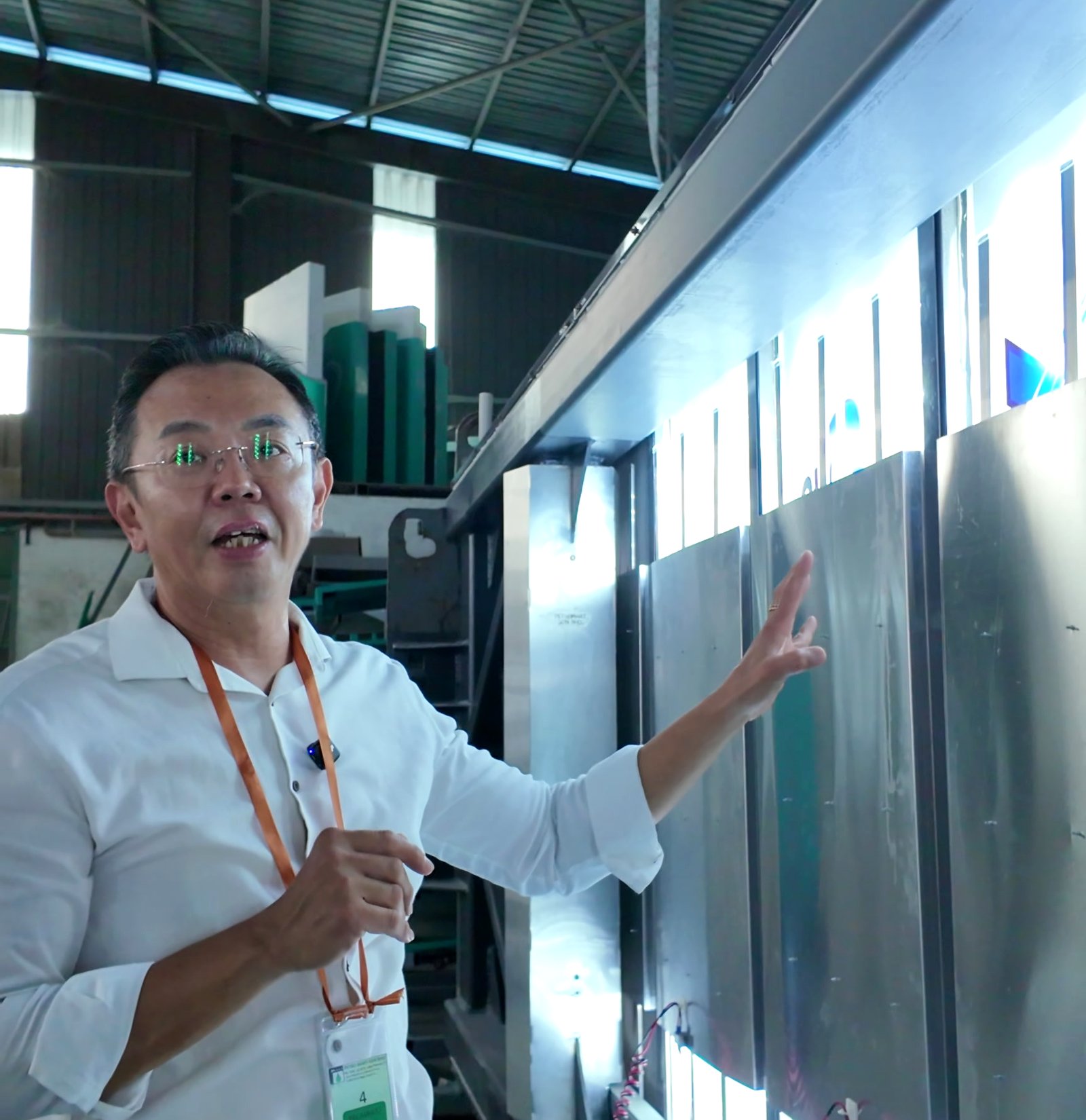 Brian Yap, founder of AVS Display, pointing out a run of backlit sign panels at a customer's fabrication plant